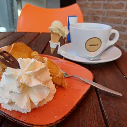 Tafel met gebak, ijs in een kegel en koffiekopje met schotel buiten op een terras