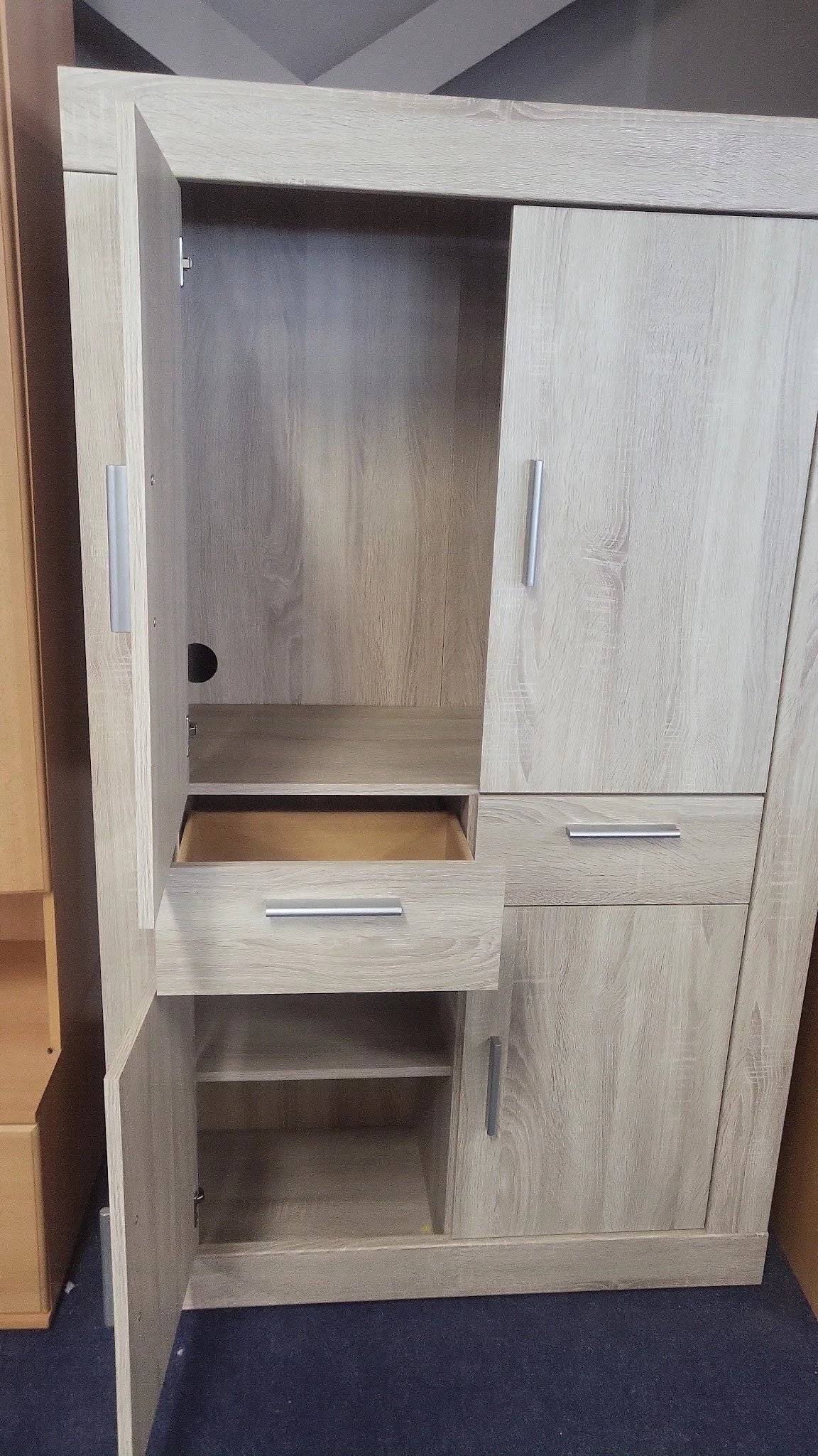Licht houten kastje met open compartiment, lades en deuren met metalen grepen