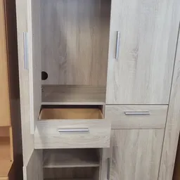 Licht houten kastje met open compartiment, lades en deuren met metalen grepen