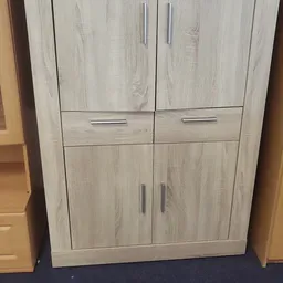 Licht houten kast met twee deuren bovenaan, twee laden in het midden en twee deuren onderaan