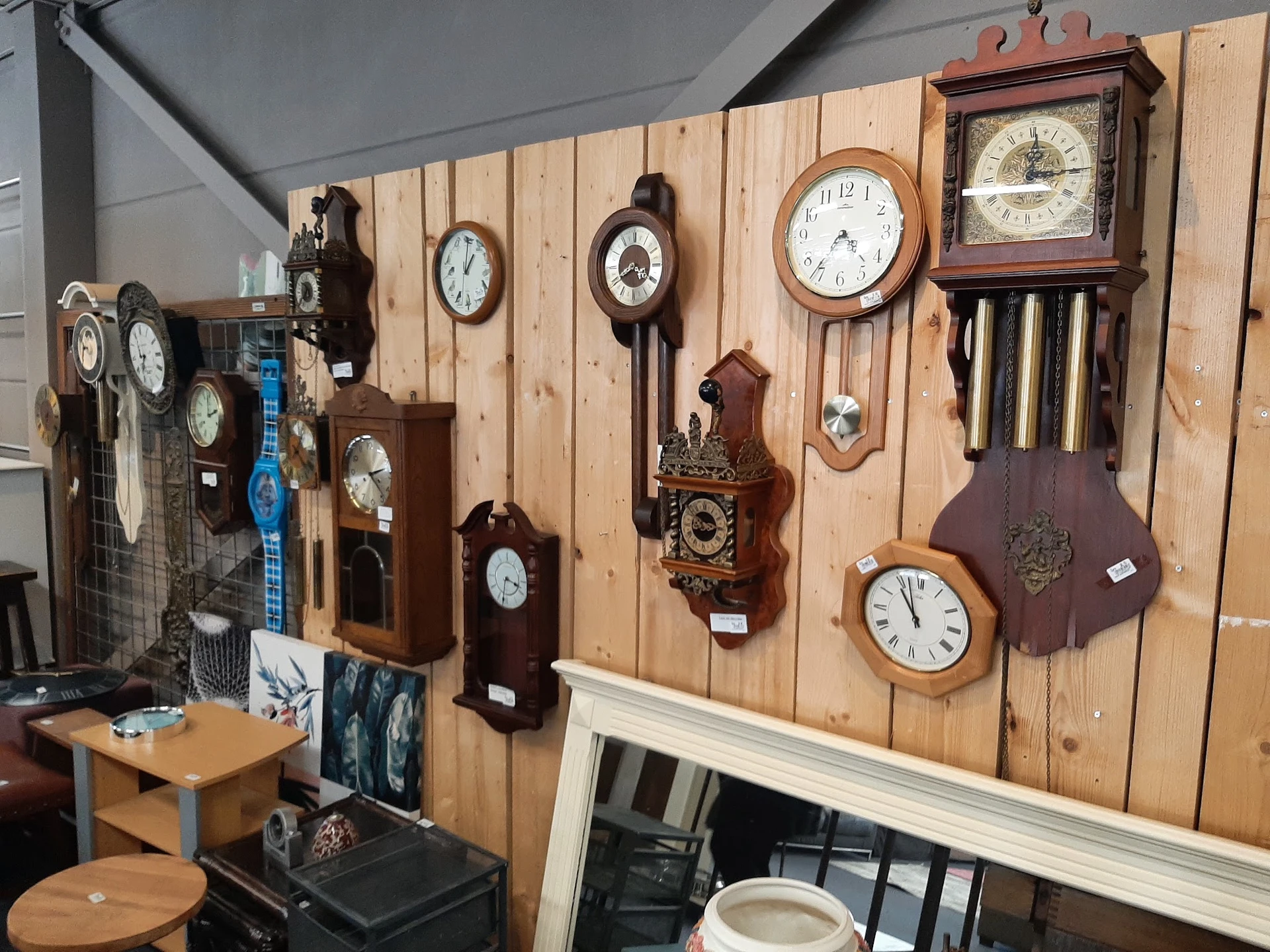 Wandklok collectie op houten display board met verschillende vintage en klassieke klokken