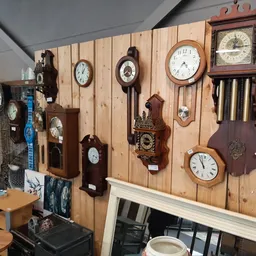 Wandklok collectie op houten display board met verschillende vintage en klassieke klokken