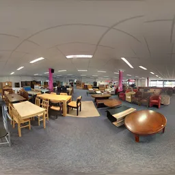Ruim winkelvloer met houten meubels, tafels, stoelen en diverse inrichtingsstukken in een kringloopwinkel