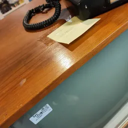 Houten werkblad met telefoon, papier en andere kantoorobjecten