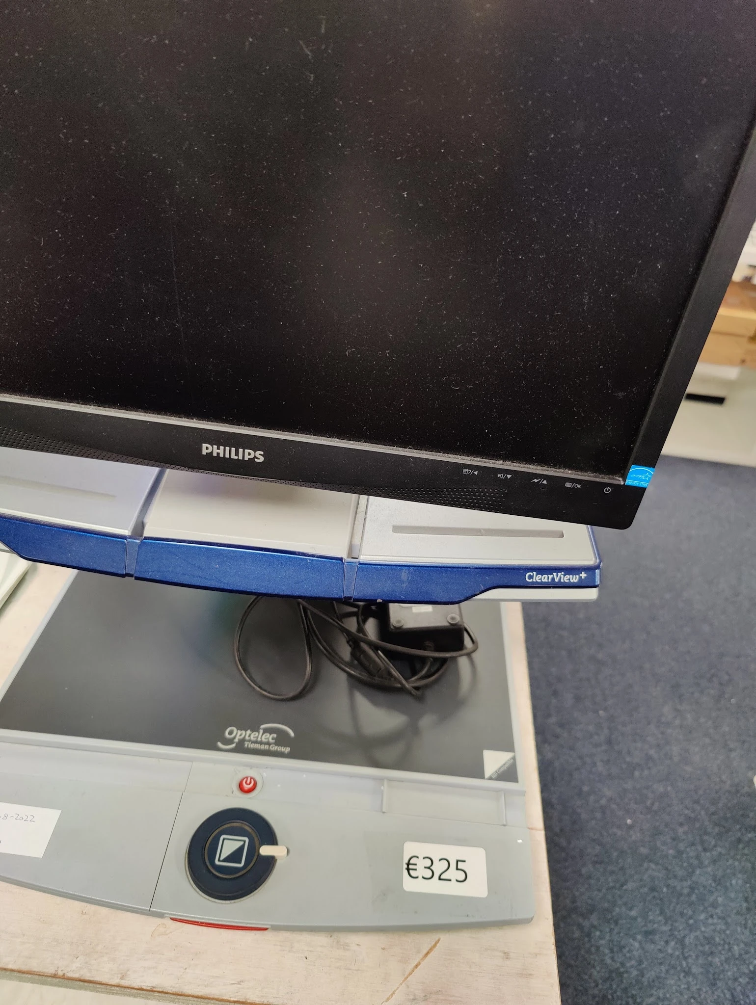 Philips computermonitor op blauwe monitorarm boven grijs bureau