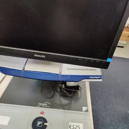 Philips computermonitor op blauwe monitorarm boven grijs bureau