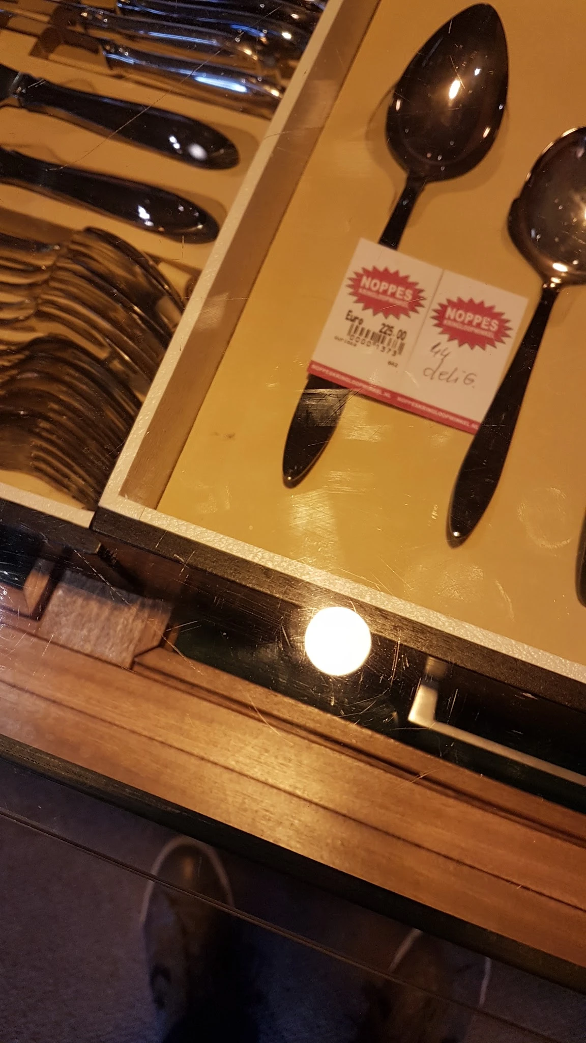 Close-up van twee donkergekleurde kwasten of penselen naast een geel voorwerp op een plank