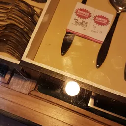 Close-up van twee donkergekleurde kwasten of penselen naast een geel voorwerp op een plank