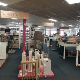 Overzicht van de winkelvloer met rekken, boeken, kleding en diverse tweedehands artikelen