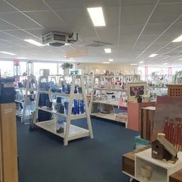 Winkelvloer van kringloopwinkel met lichte stellingen vol spullen, goede verlichting en overzichtelijke indeling