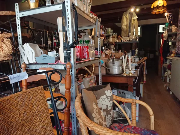 Winkelinterieur met stellingen, meubels, huishoudartikelen en diverse tweedehands spullen uitgestald