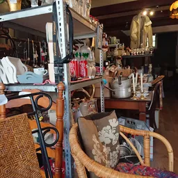 Overzicht van kringloopwinkel met stellingen vol huishoudartikelen, meubels en diverse spullen