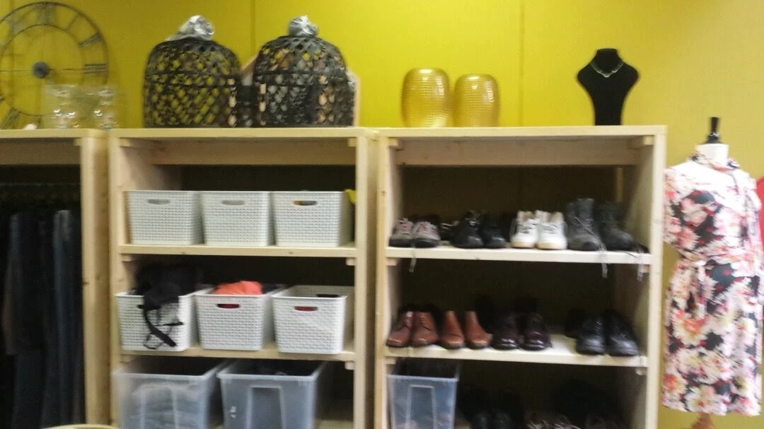 Winkelkasten met opbergmanden, schoenen en accessoires in een kringloopwinkel