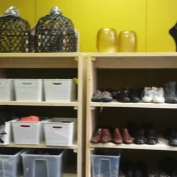 Winkelkasten met opbergmanden, schoenen en accessoires in een kringloopwinkel