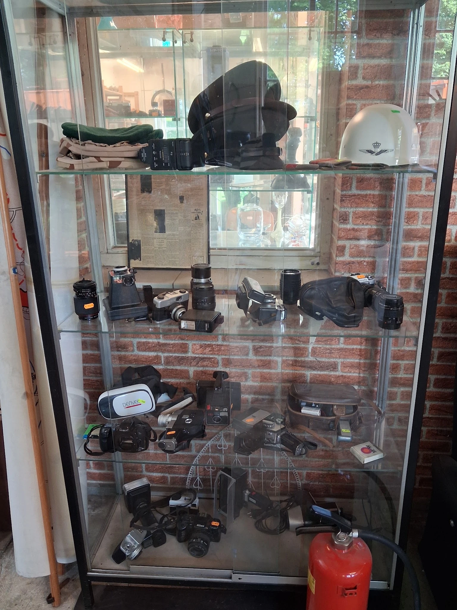 Glazen vitrine met vintage fotocamera's en filmapparatuur uit verschillende decennia