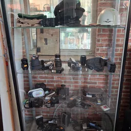 Glazen vitrine met vintage fotocamera's en filmapparatuur uit verschillende decennia