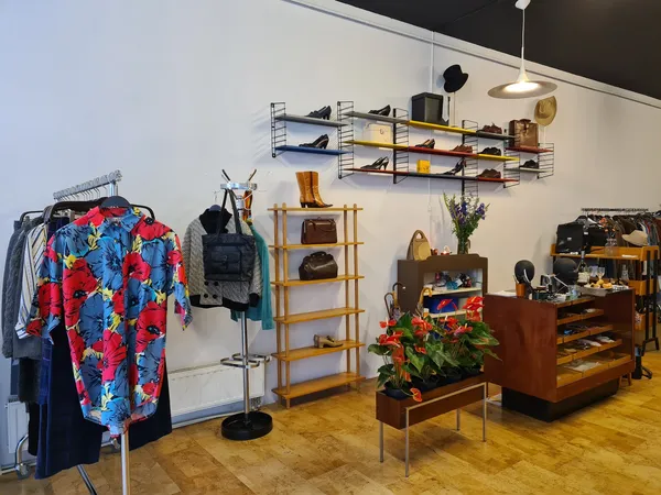Winkelvloer met kledingrekken, houten kasten, wandplanken en diverse tweedehands artikelen