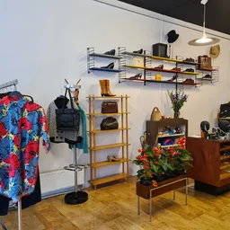 Winkelvloer met kledingrekken, houten kasten, wandplanken en diverse tweedehands artikelen