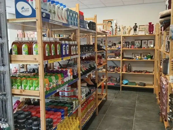 Overzicht van de winkelvloer met houten stellingen vol verschillende producten en huishoudgoederen