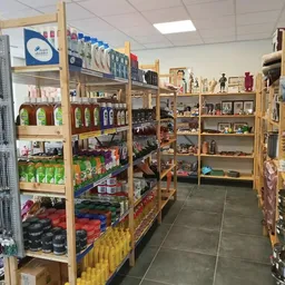 Houten stellingen met diverse tweedehands artikelen in een kringloopwinkel, inclusief schoonmaak- en verzorgingsproducten