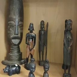 Zwarte houten beelden en maskers uit Afrika op display
