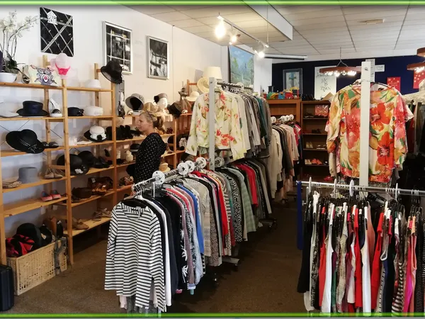 Winkelvloer met kledingrekken, houten stellingen met accessoires en decoratie-items