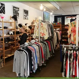 Winkelvloer met kledingrekken, houten stellingen met accessoires en decoratie-items