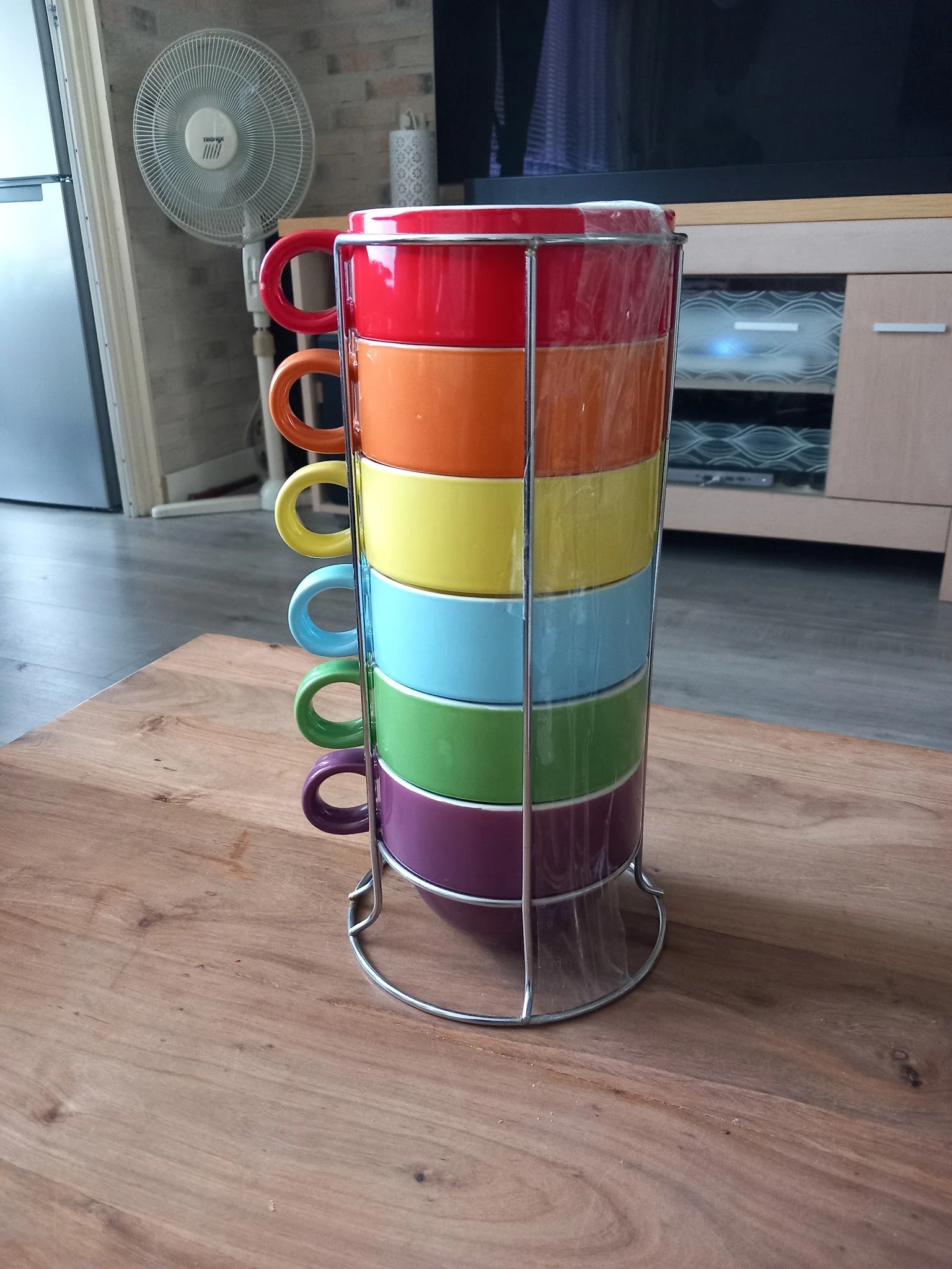 Regenboogkleurige stapelbare bekers met hengsels op een metalen standaard