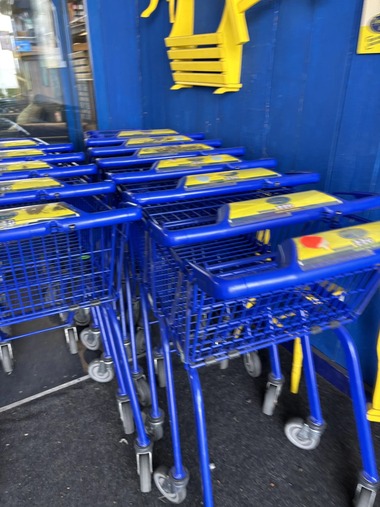 Rij blauw-gele winkelwagentjes opgesteld in de winkel