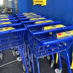 Rij blauw-gele winkelwagentjes opgesteld in de winkel