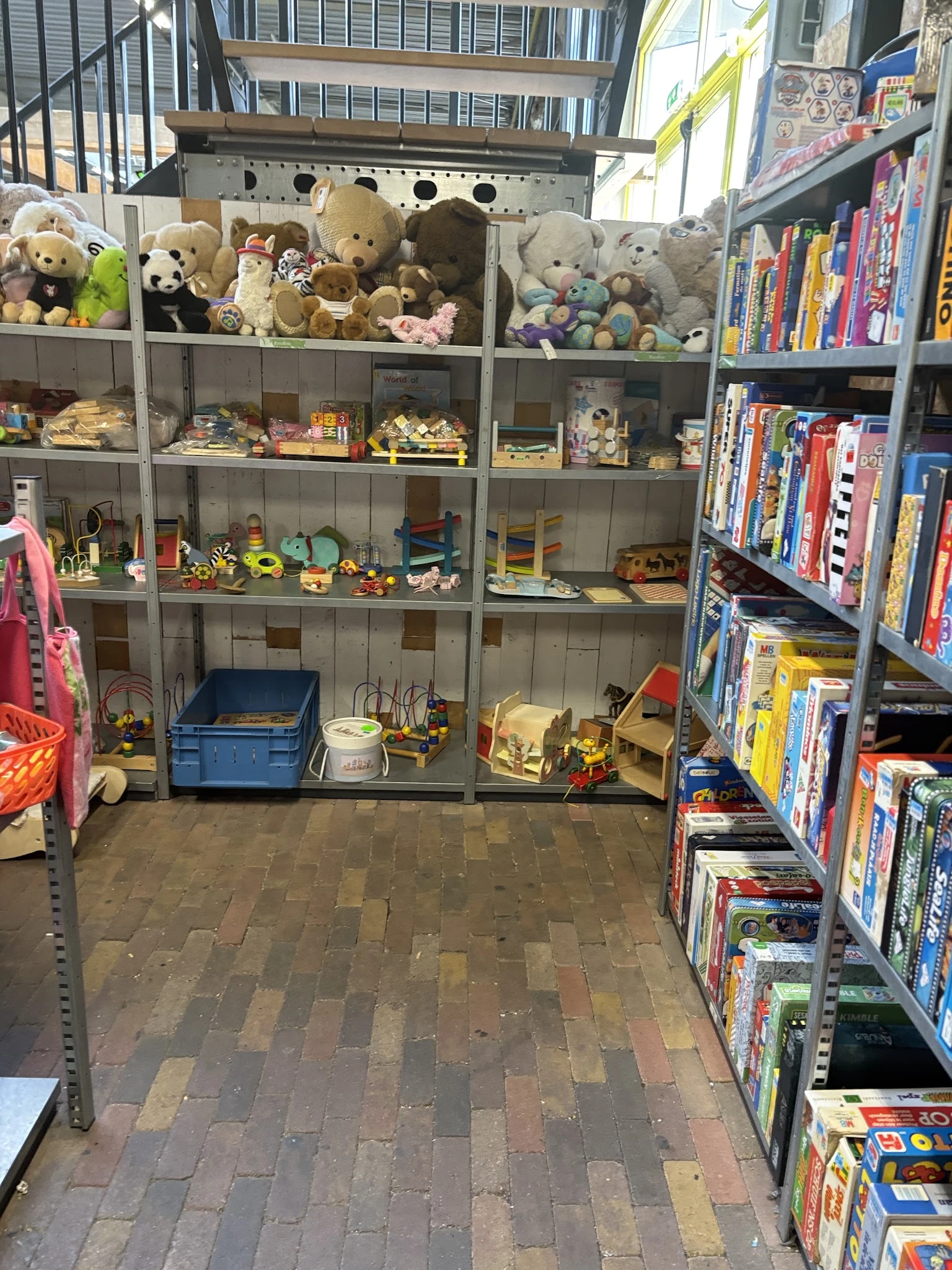 Glazen vitrinekasten vol met speelgoed, boeken en diverse tweedehandsartikelen in een kringloopwinkel