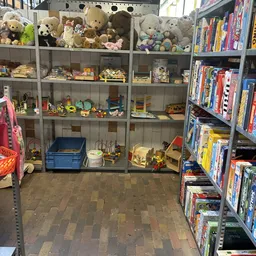 Glazen vitrinekasten vol met speelgoed, boeken en diverse tweedehandsartikelen in een kringloopwinkel