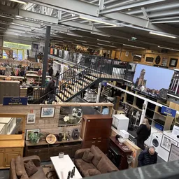Overzicht van de winkelvloer met meubels, huishoudartikelen en diverses items op verschillende niveaus