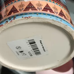 Onderkant van een decoratief bord met een prijssticker en barcode