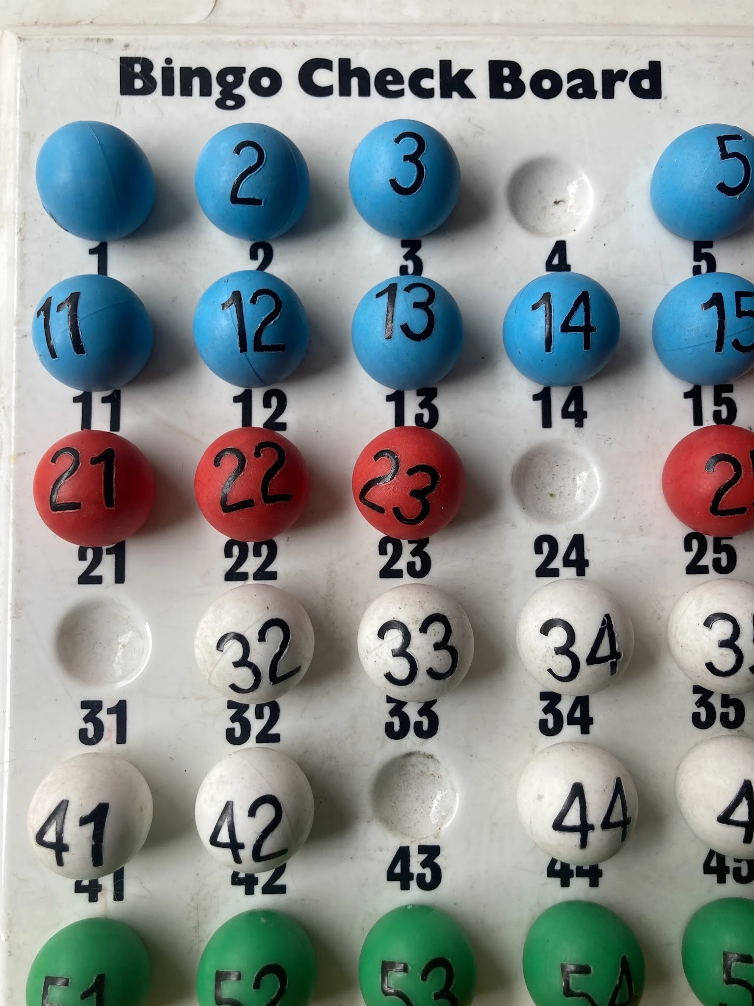 Bingo kaarten met genummerde ballen in blauw, rood en wit