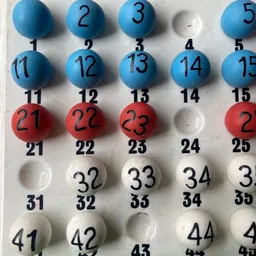 Bingo kaarten met genummerde ballen in blauw, rood en wit