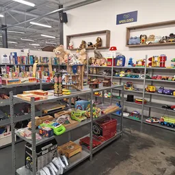 Winkelvloer met stellingen vol speelgoed, boeken en huishoudartikelen in verschillende afdelingen
