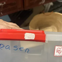 Close-up van een rode doos met witte sticker en tekst 'pasen' erop