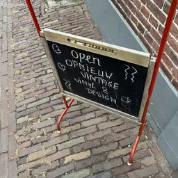 Krijttekening op zwart bord met handgeschreven tekst over openingstijden en winkelcategorieën