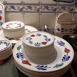 Gestapeld servies met blauwe en rode bloemdessin, borden en kopjes netjes uitgestald