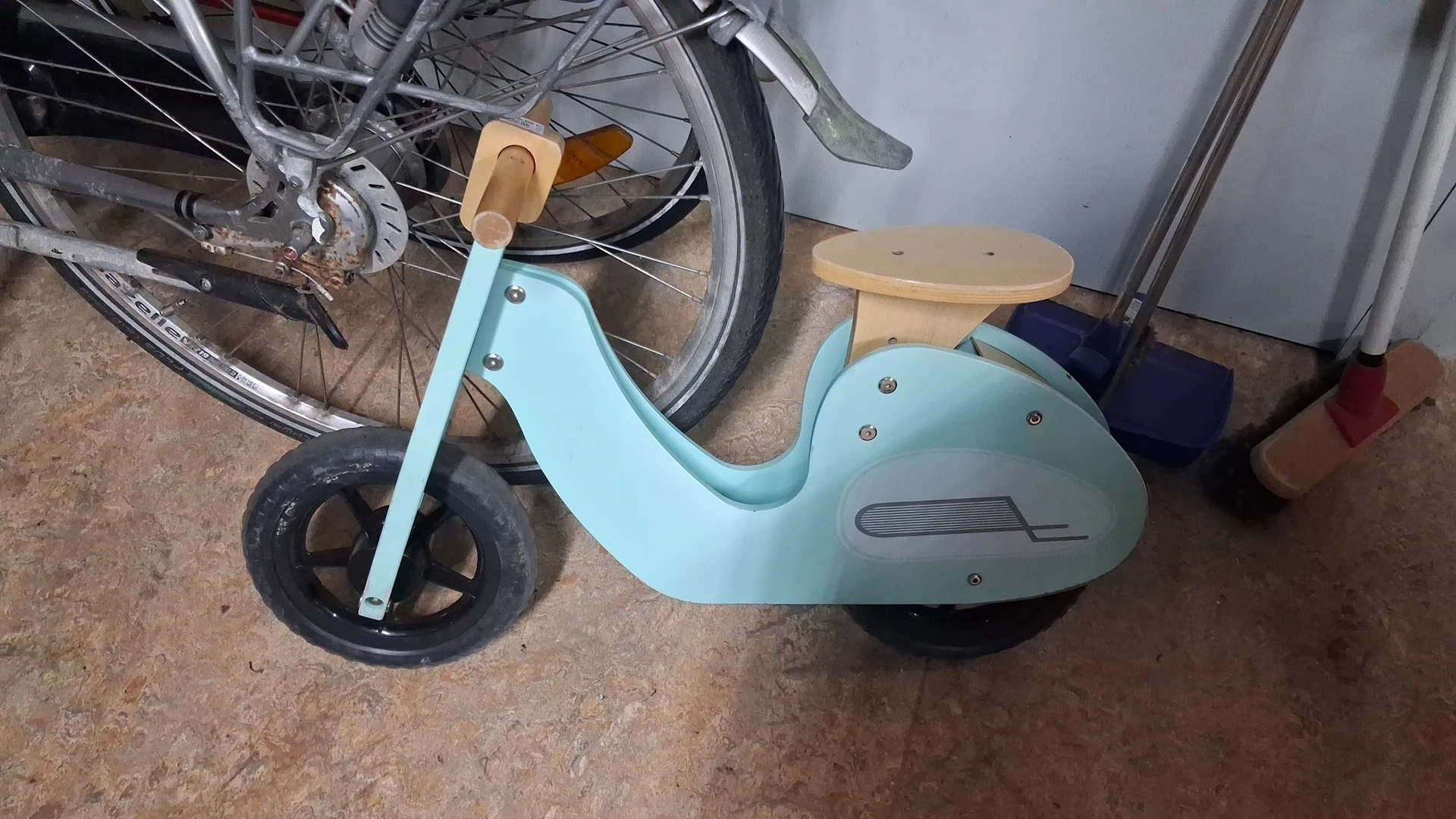 Turquoise loopfiets voor kinderen met houten zitting en zwarte wielen