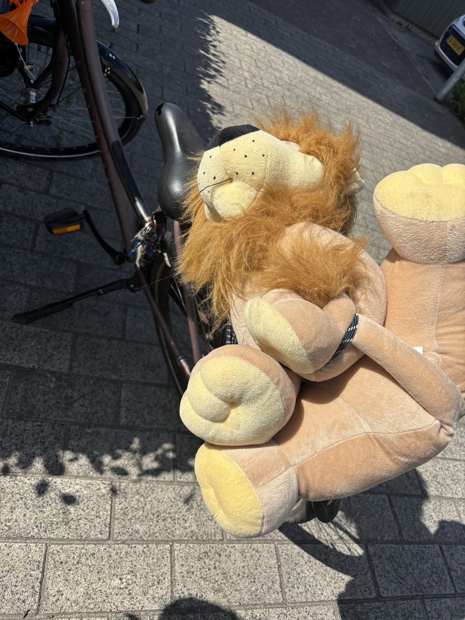 Close-up van een pluchen knuffel in de vorm van een leeuw met bruine manen en crème-kleurige buik en poten