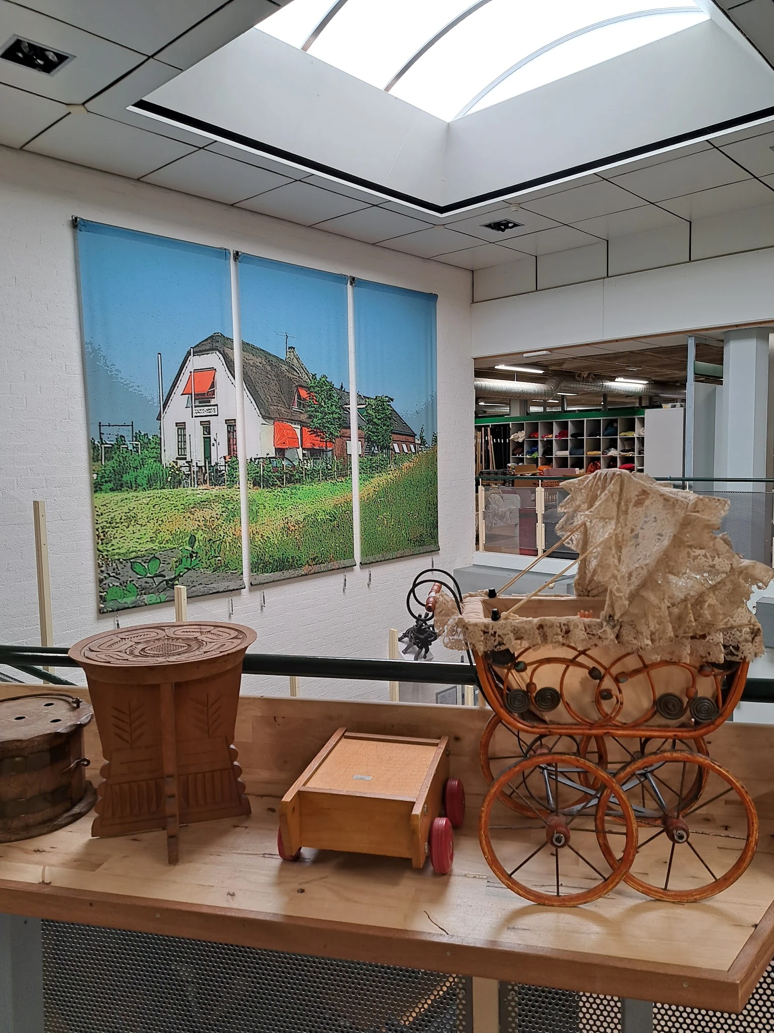 Winkelinterieur met nostalgische foto aan wand, vintage huishoudartikelen en meubelstuk op display
