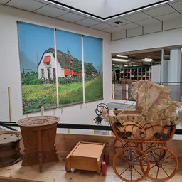 Winkelinterieur met nostalgische foto aan wand, vintage huishoudartikelen en meubelstuk op display