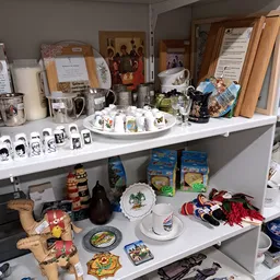 Winkelschappen met verzameling servies, bekers, decoratieve bordjes en diverse huishoudartikelen