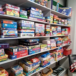 Stellingen vol met bordspellen en puzzels in dozen, kleurig en diverse aanbod