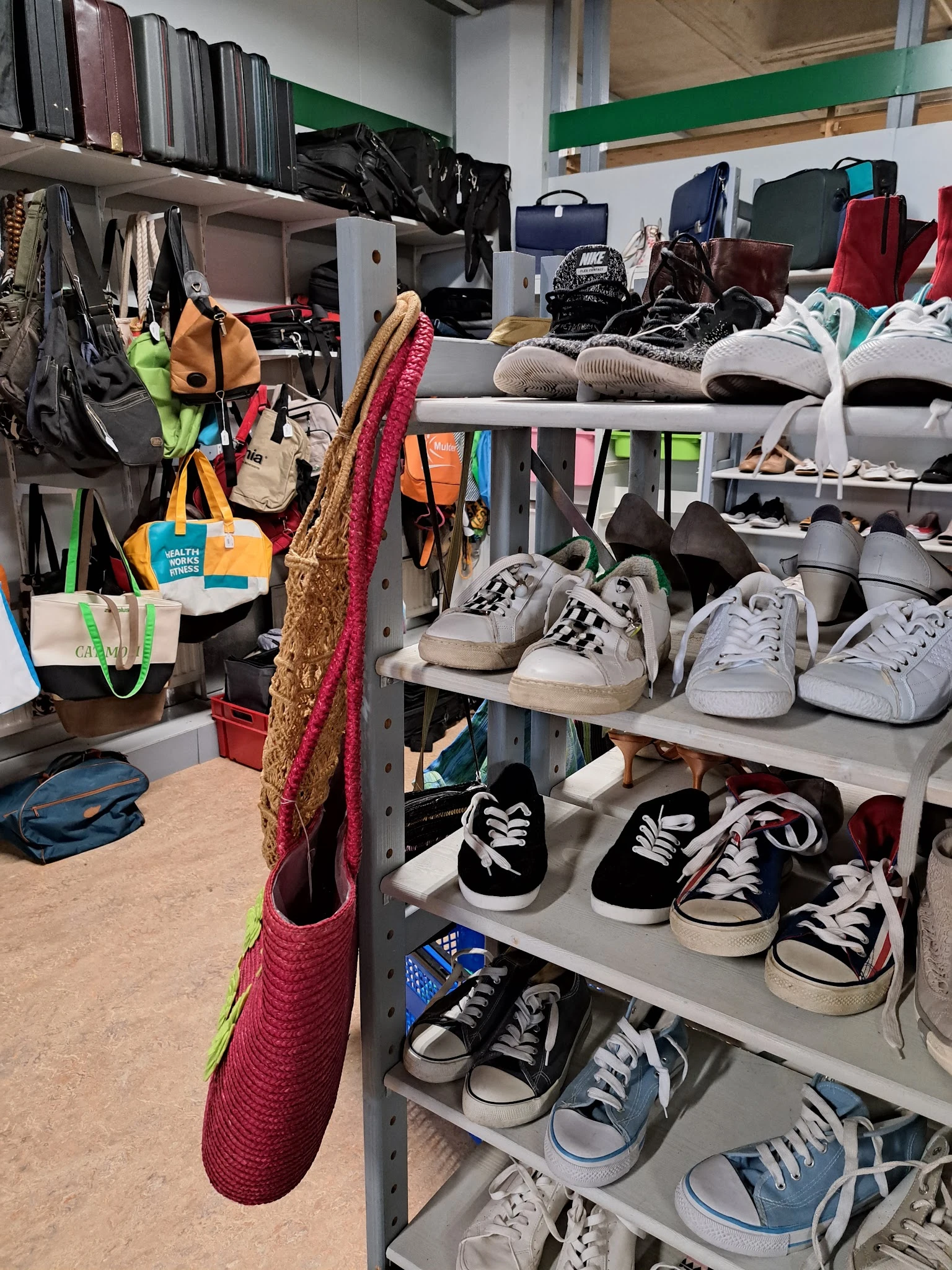 Stellingen met uitgestalde tweedehands schoenen en sneakers in verschillende kleuren en maten