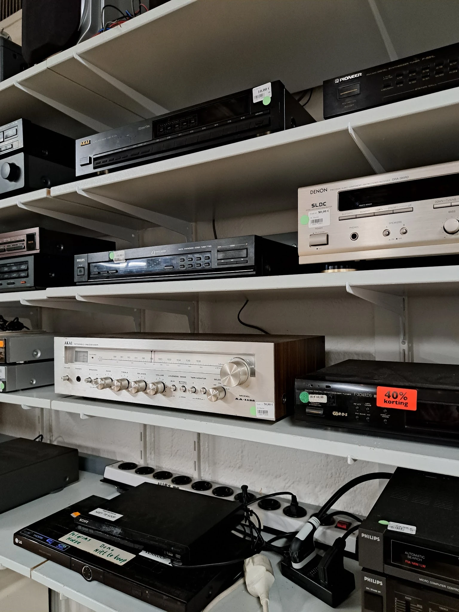 Stellingen met vintage audio-apparatuur en elektronische componenten zoals versterkers en cd-spelers
