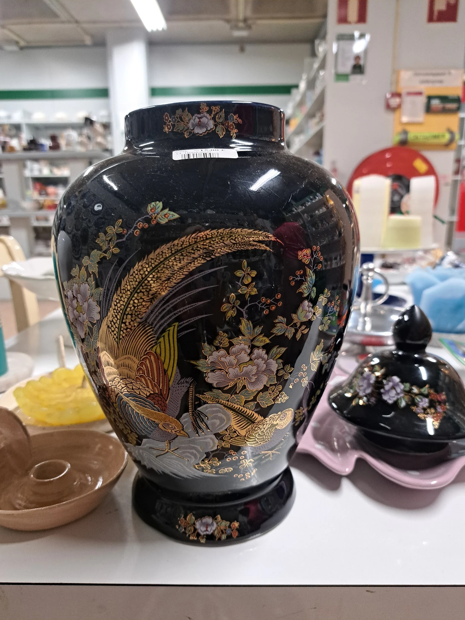 Zwarte vaas met gouden decoraties van vogels en bloemen, close-up