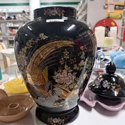 Zwarte vaas met gouden decoraties van vogels en bloemen, close-up